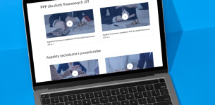 Komputer na niebieskim tle, na ekranie wyświetlana strona internetowa